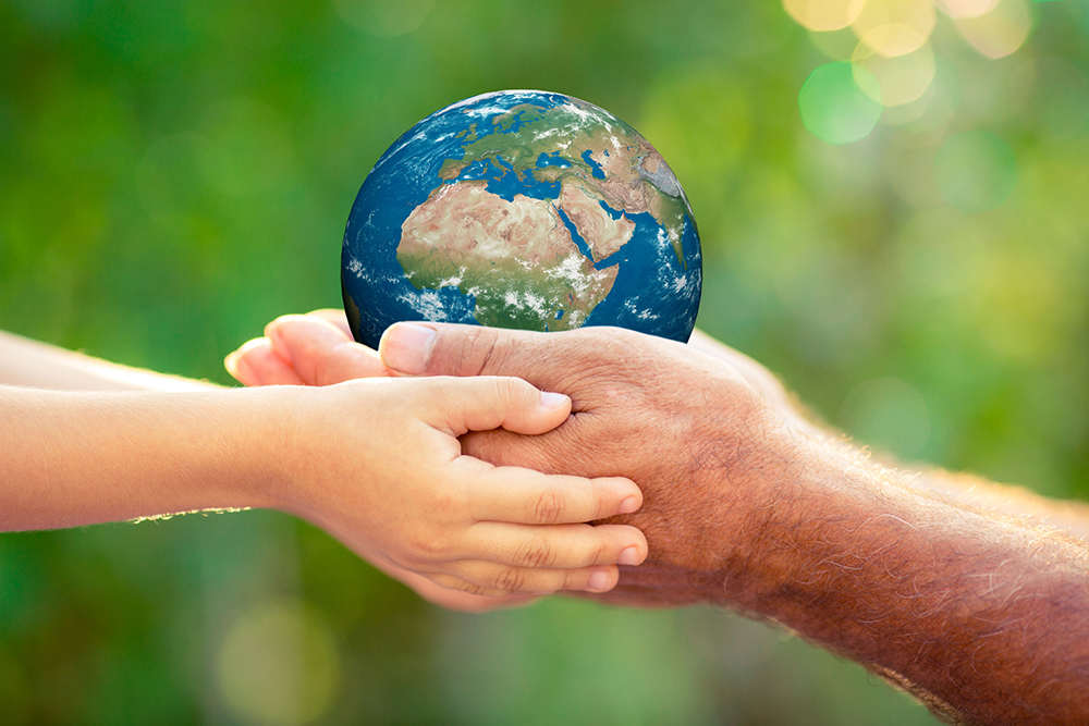 37598718 - child and senior holding 3d planet in hands against green spring background. earth day holiday concept.